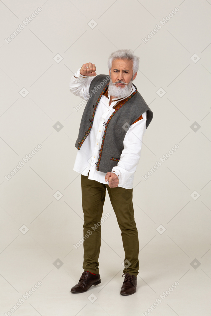 Angry man looking at camera and showing clenched fist