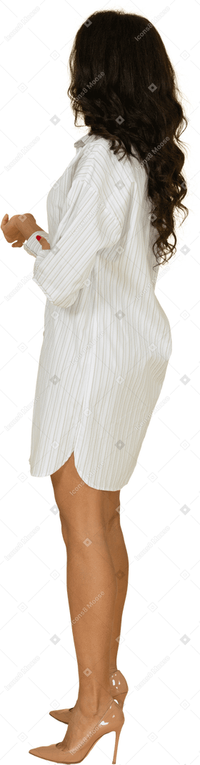 体贴的黑皮肤的年轻女性，在白色的连衣裙，镀金手中的侧视图