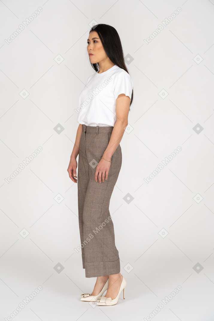 Three-quarter view of a young woman in breeches standing still