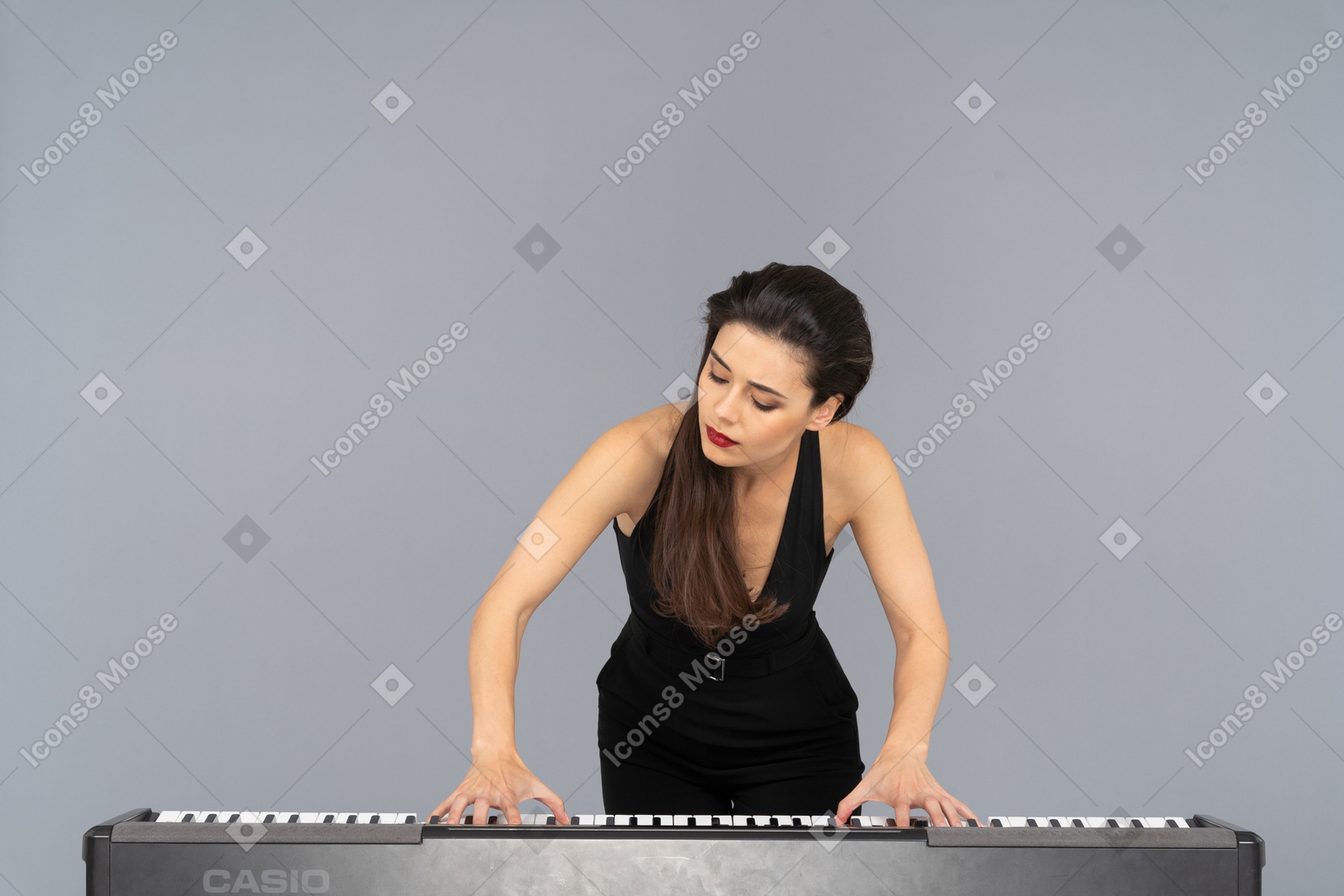 一位年轻的女士，穿着黑色连衣裙弹钢琴的前视图