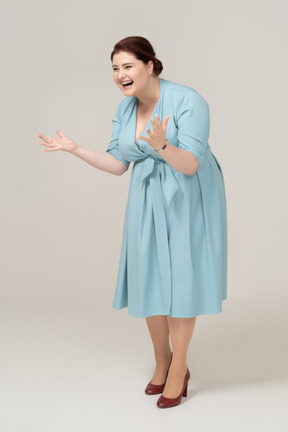Femme heureuse en robe bleue posant de profil