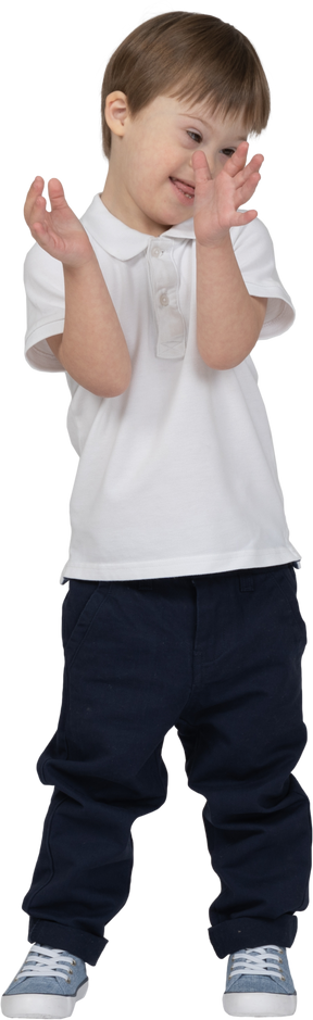 Front view of a boy clapping shyly