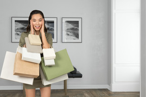 Young shocked woman holding shopping bags