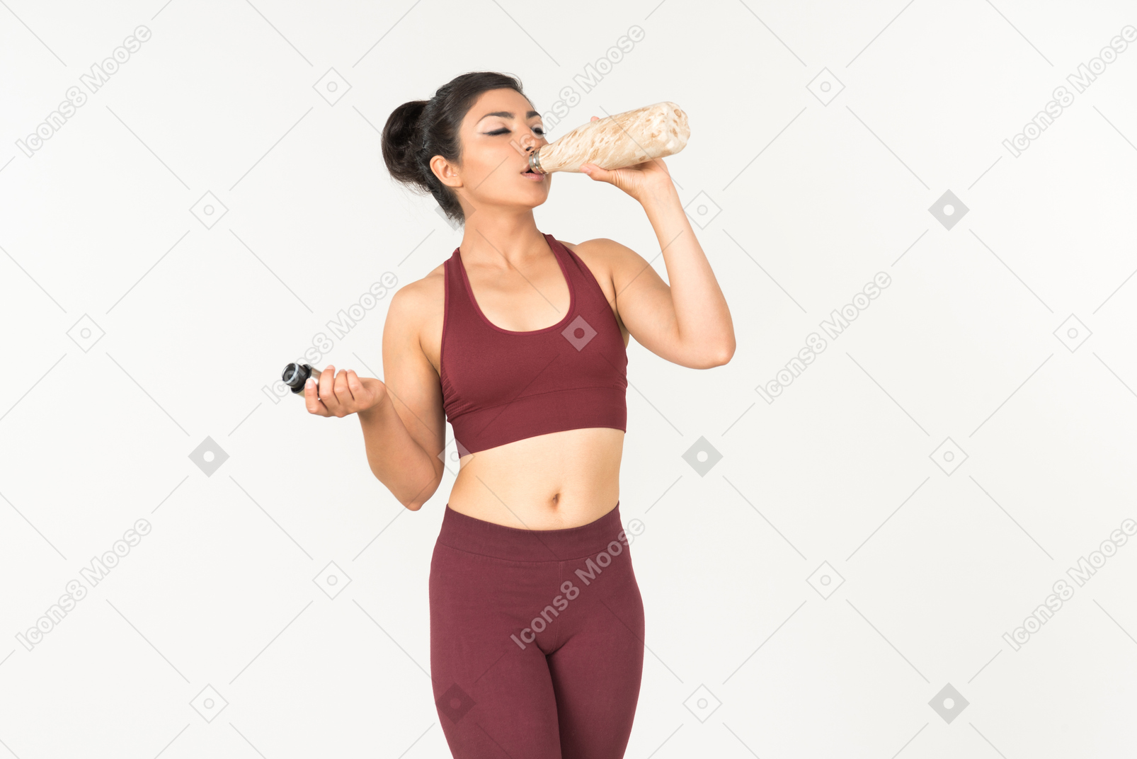 Young indian woman in sportswear drinking water