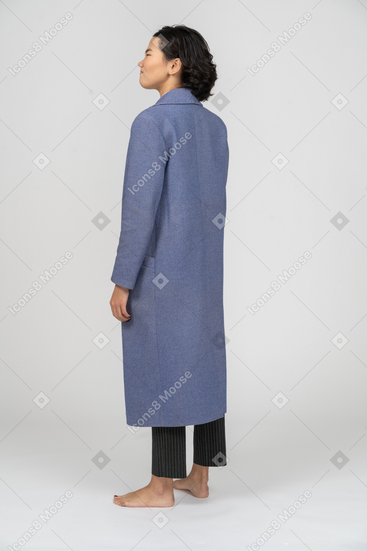 Vista posteriore di una donna arrabbiata in cappotto blu