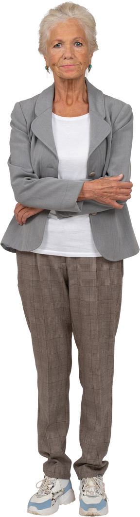 Front view of an old lady in suit posing with crossed arms and looking at camera