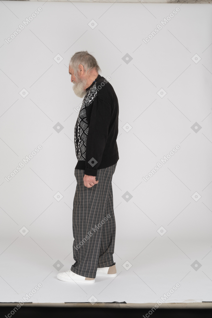 Vista laterale di un uomo anziano in piedi e guardando in basso