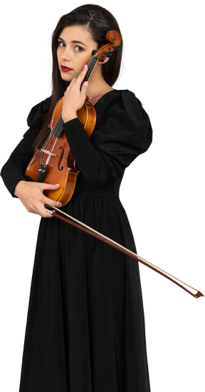 一位年轻的女士，穿着黑色的连衣裙，拿着小提琴的特写镜头
