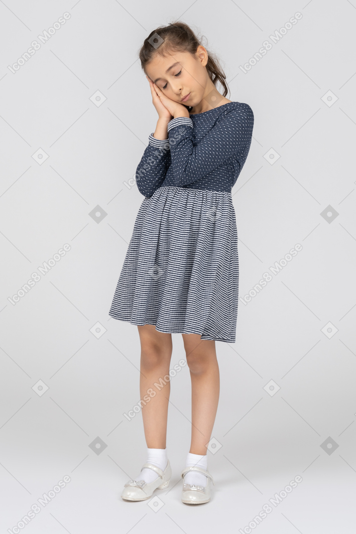 A sleeping little girl in a blue dress and white shoes