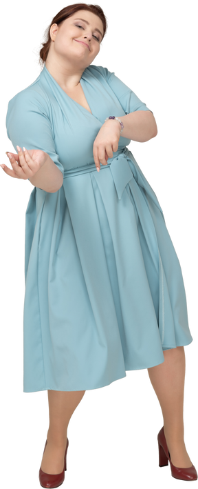 Front view of a woman in blue dress pretending that she is playing the violin