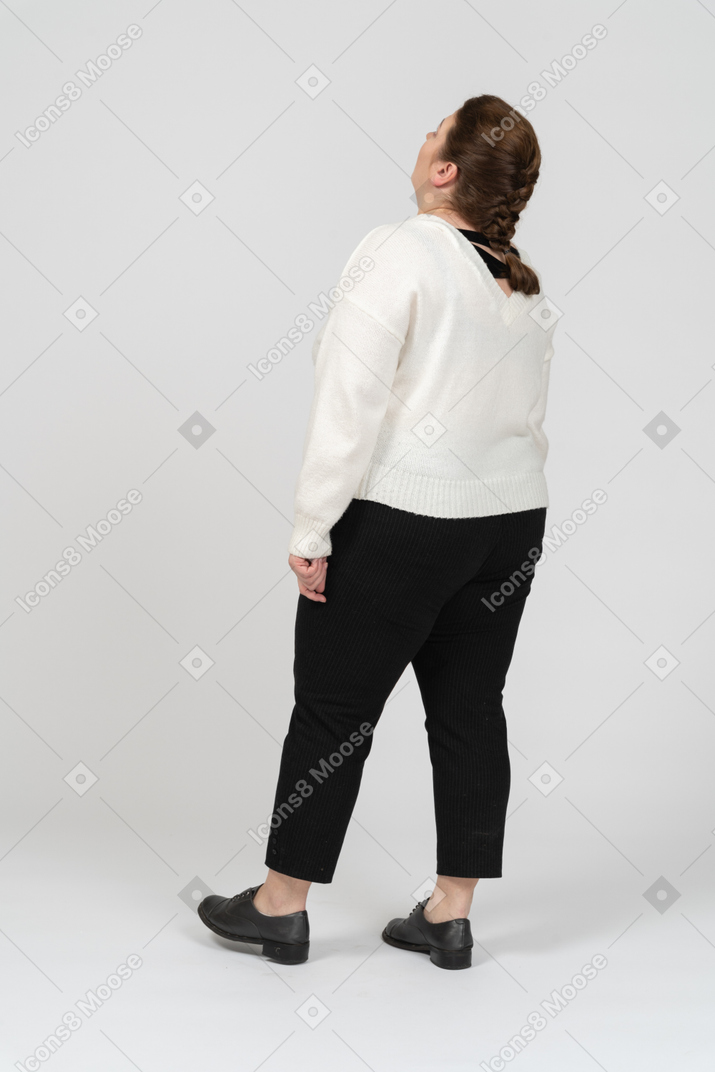Plump woman in casual clothes looking up