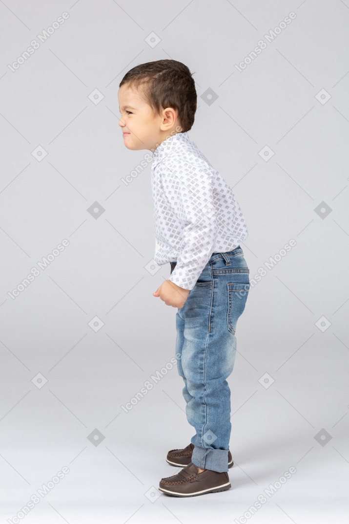 Little boy standing with his fist clenched and evil grin on his face