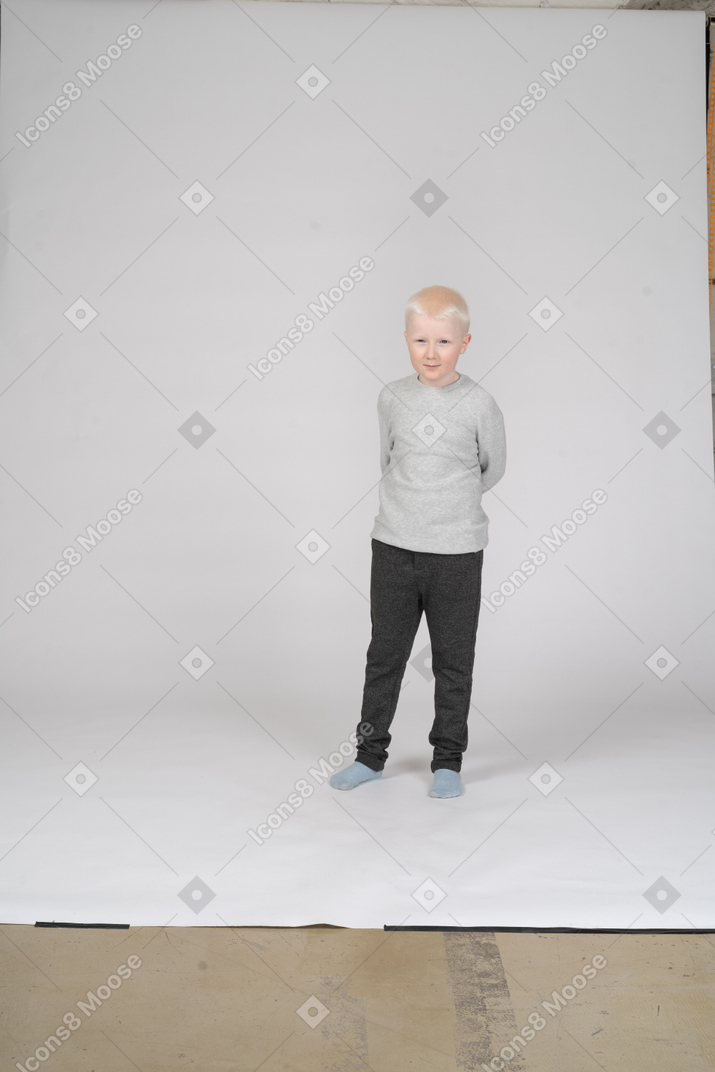 Front view of a shy little boy in casual clothes