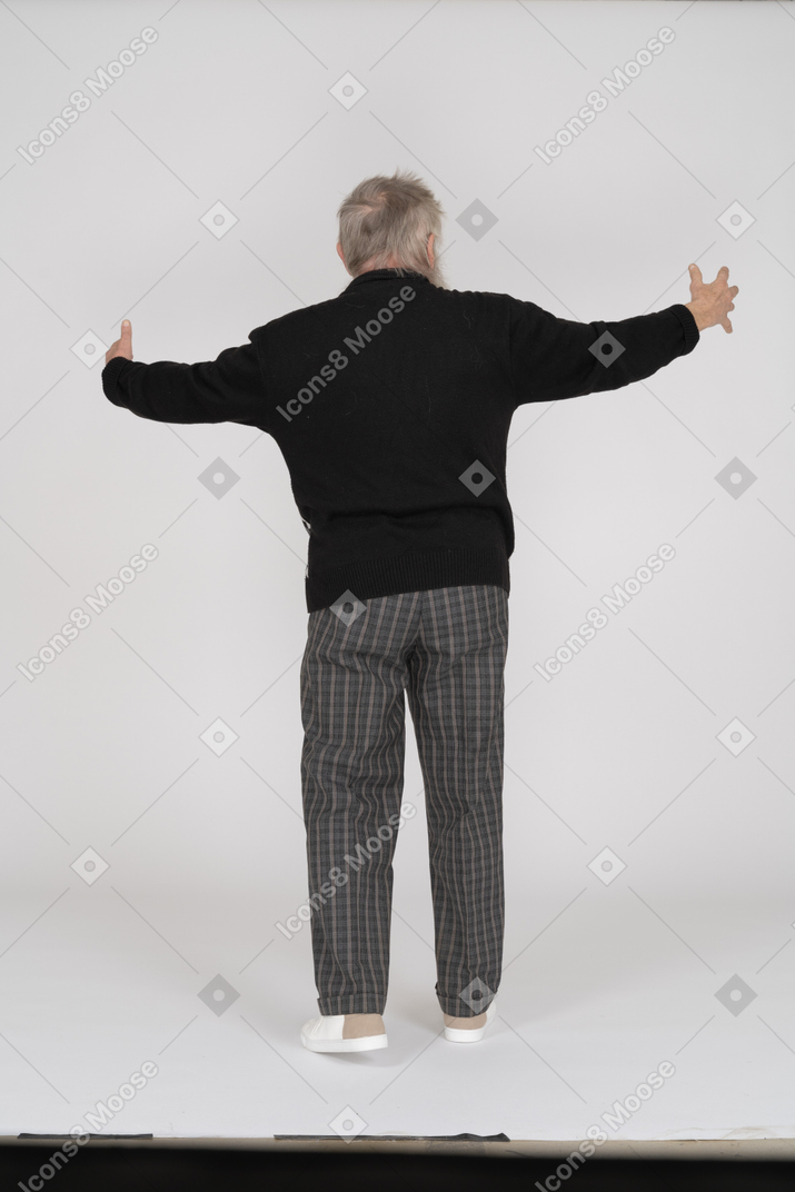 Rear view of old man showing big gesture with arms