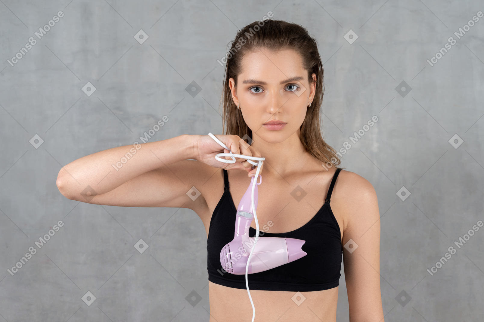 Attractive young woman with hairdryer cord wrapped around hand