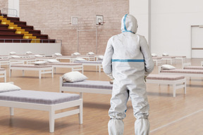A person in a protective suit standing in a temporary hospital