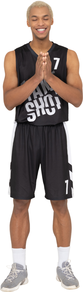 Vista frontal de um jovem sorridente jogador de basquete de mãos dadas