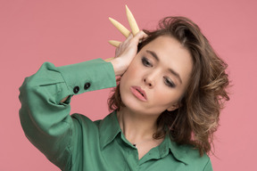 Woman holding baby corns next to ear