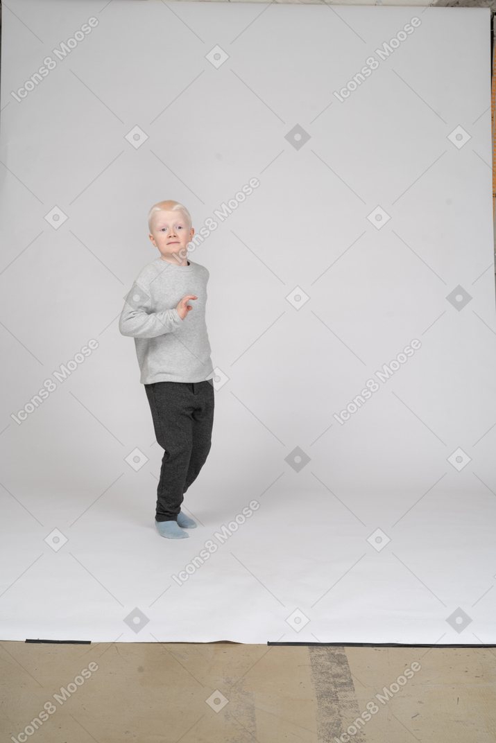 Vista frontal de un niño sorprendido gesticulando