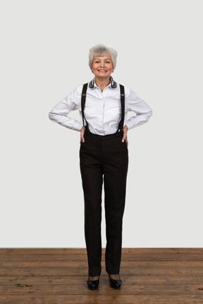 Full-length of a delighted old female in suspenders putting hands on hips