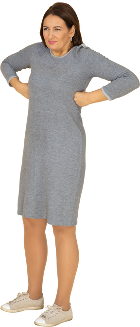 一个穿着灰色裙子摆姿势的女人的前视图