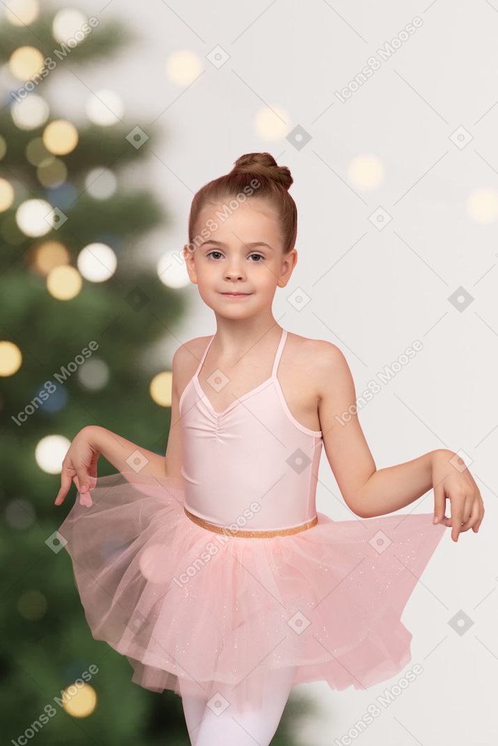 Little girl standing in front of the christmas tree