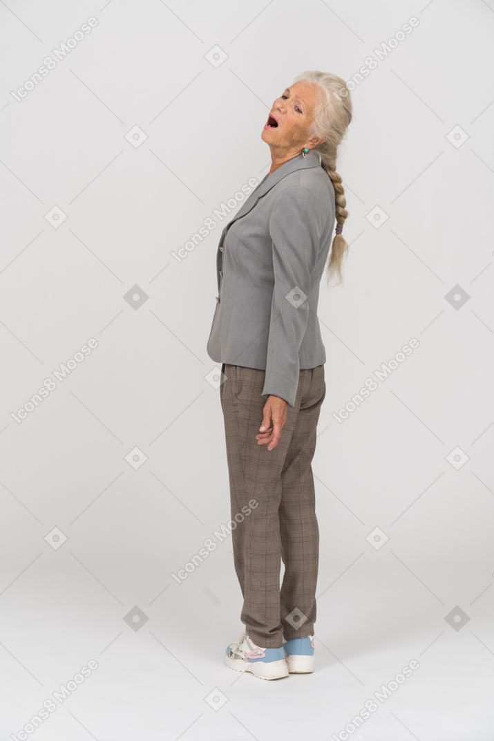 一位情绪激动的老妇人张开嘴站立的后视图