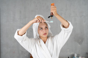 Frau im bademantel drückt zahnpasta aus der tube