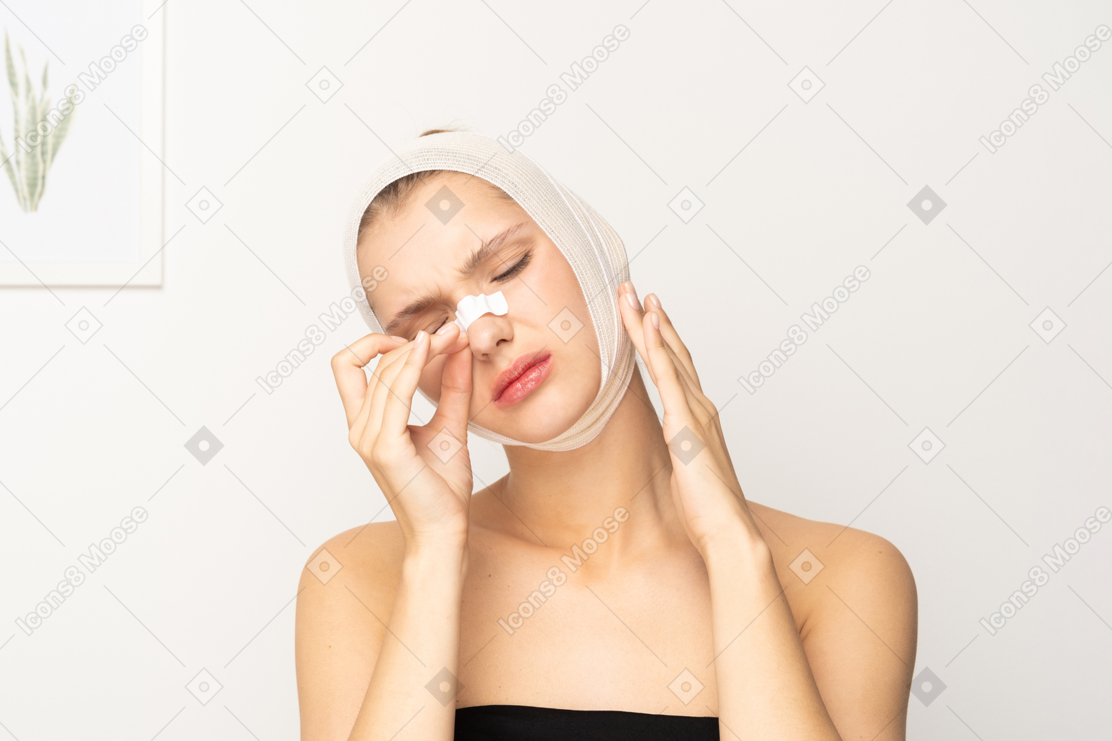 Young woman with bandaged head removing plaster