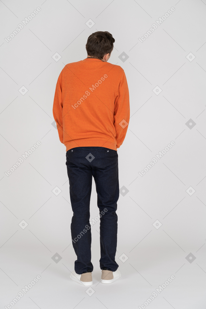 Young man in orange sweatshirt standing