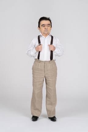 Middle-aged man holding his suspenders and looking aside