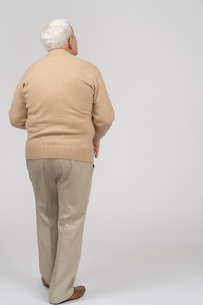 Rear view of an old man in casual clothes looking up