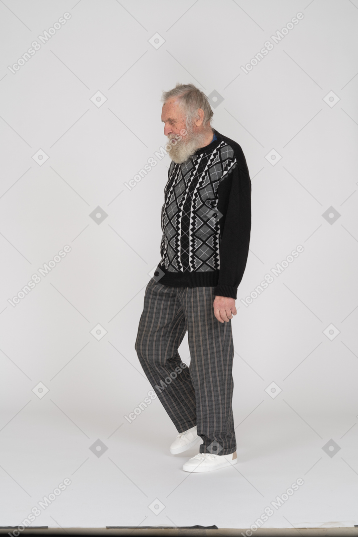 Vista lateral de un anciano caminando