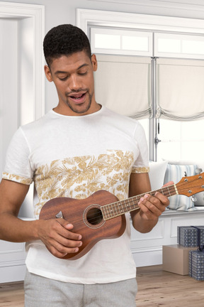 A man playing a ukulele in a kitchen