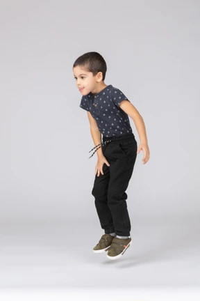 Side view of a cute boy jumping