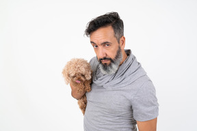 Mature man with serious face holding a puppy