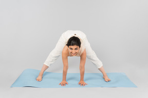 Young indian woman standing in pose on yoga mat