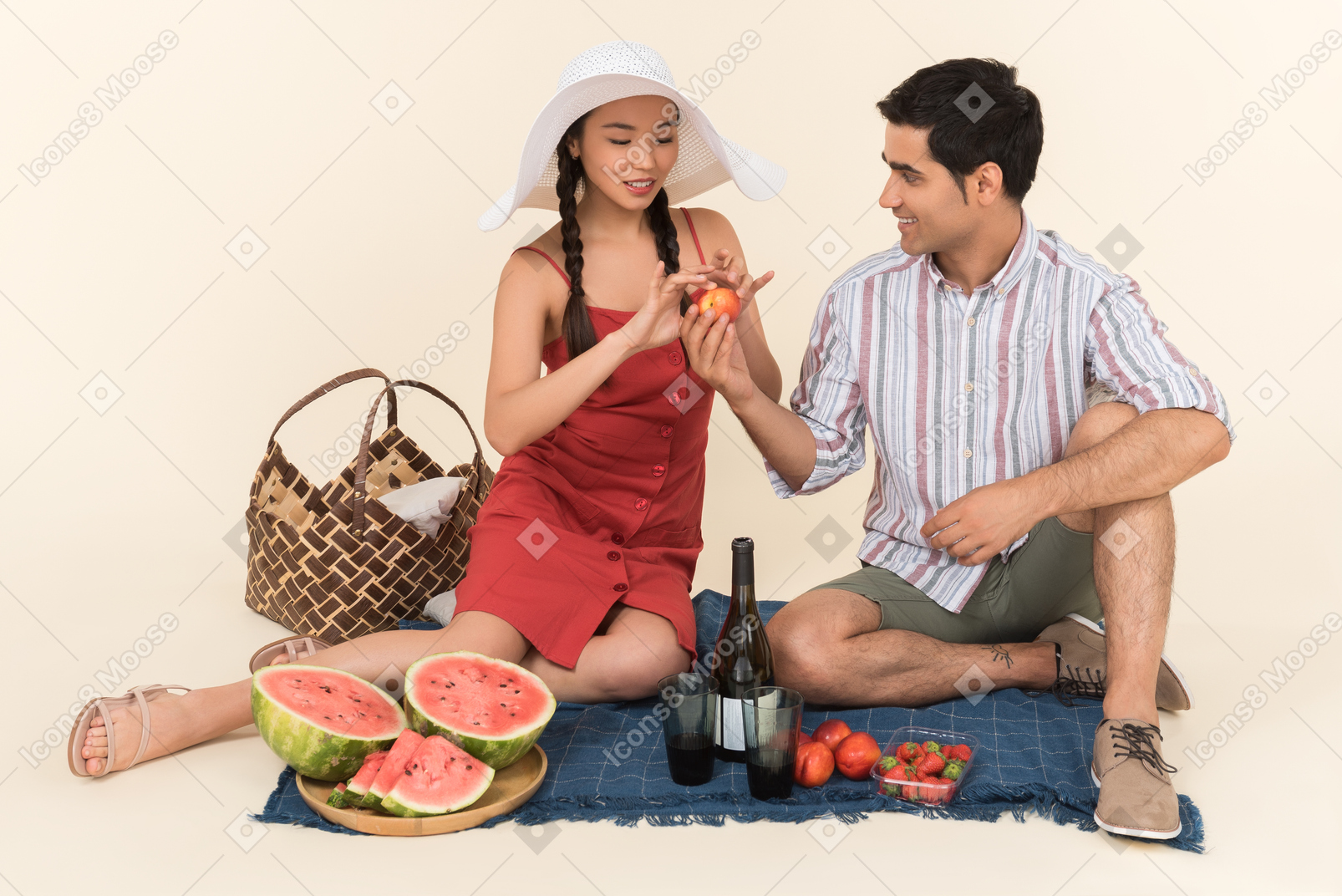 Joven dando frutos a una niña mientras hacen un picnic