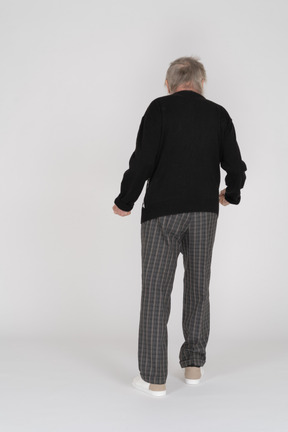 Back view of an elderly man with clenched fists