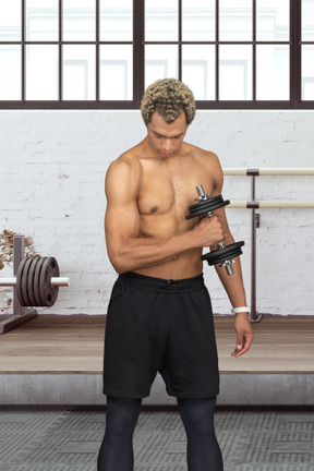 A topless sportsman holding a dumbbell