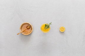 Ciotola di miele, limoni e succo di limone con foglie di rosmarino