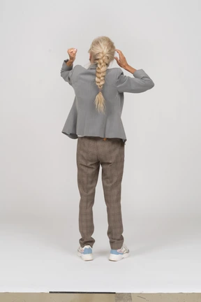 Back view of an old lady in suit showing fist