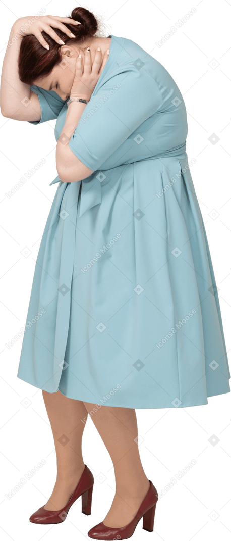 Vista lateral de uma mulher de vestido azul tocando a cabeça