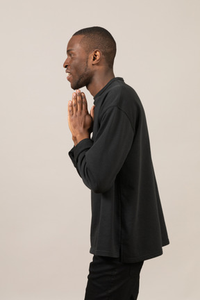 Side view of a man with praying hands