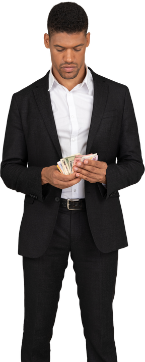 紙幣を保持している黒いスーツを着た若い男の正面図