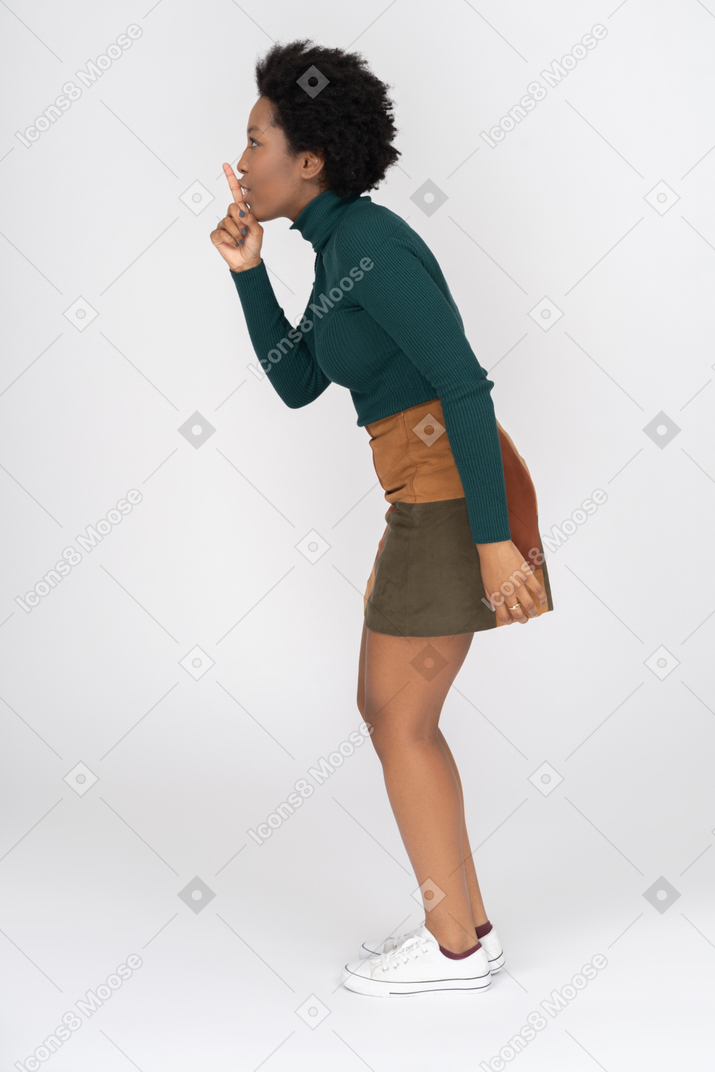 Cute african girl making a quite sound gesture in profile