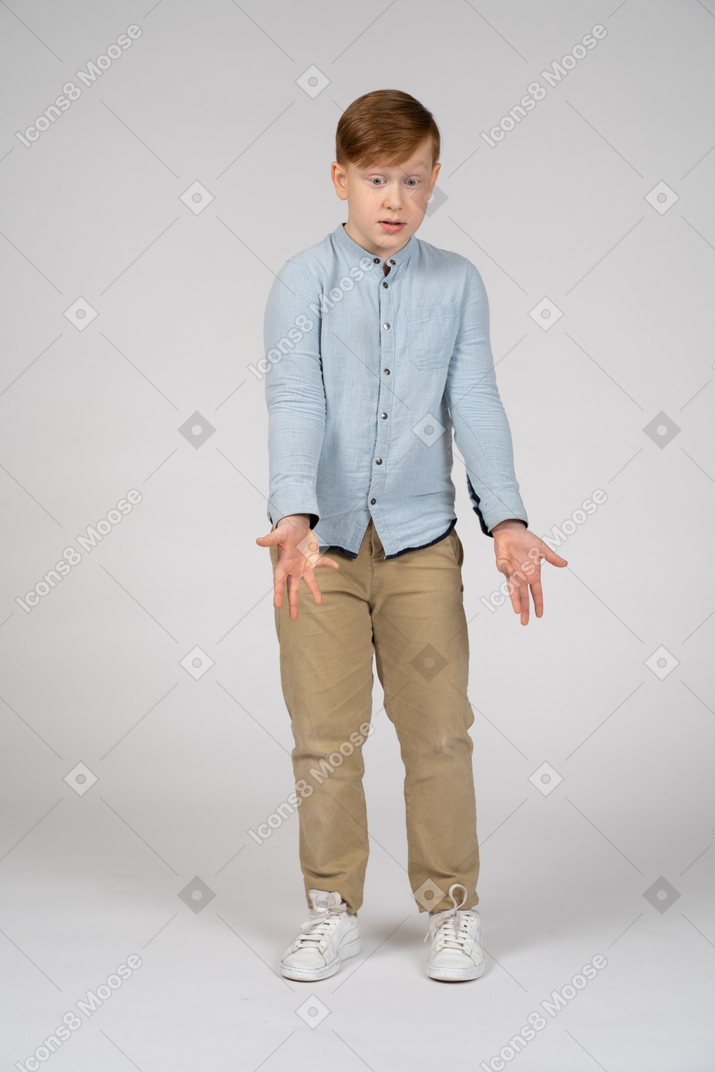 Front view of a boy pointing to a floor