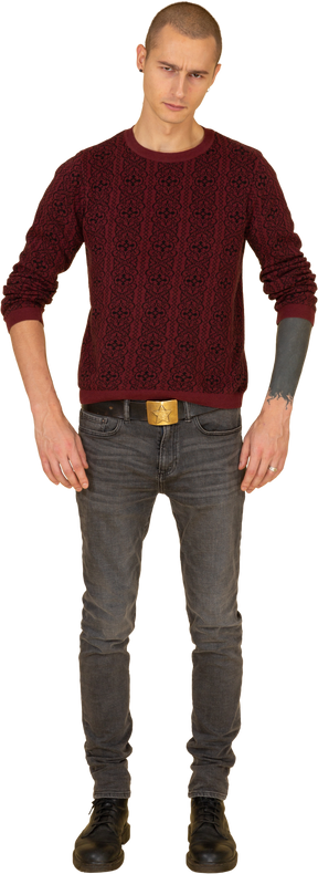 Vista frontal de um jovem de camisola colocando as mãos na cintura