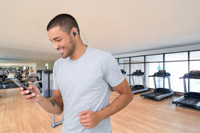 A man in a gym looking at his cell phone
