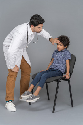 Menino sentado na cadeira e médico